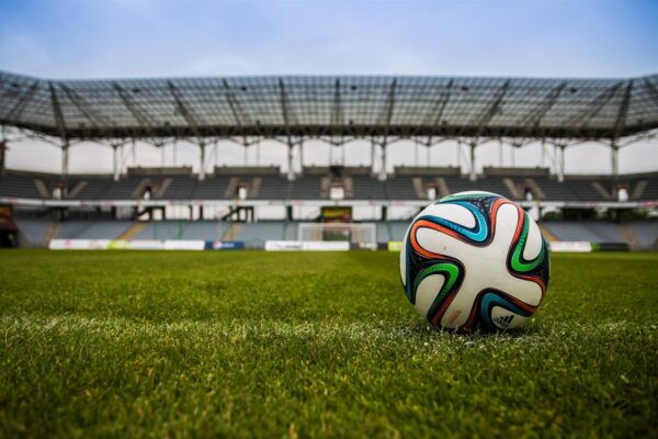 Un balón de fútbol en el campo verde de un estadio de fútbol para representar uno de los eventos deportivos más importantes de 2025.